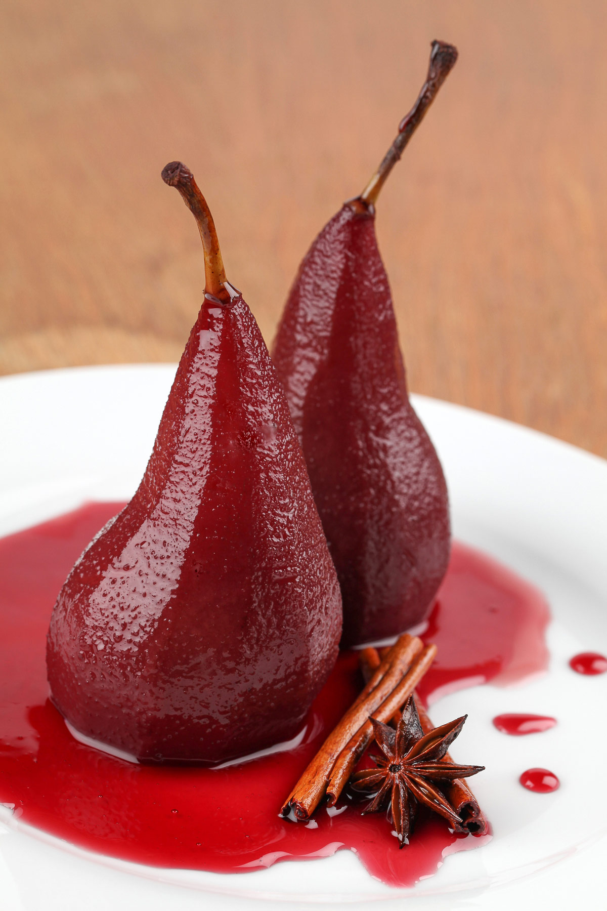 Pears, stained red by the red wine poaching liquid, on white plate, perfect for the holidays or any special occasion; Red Wine Poached Pears, Jane Bonacci, The Heritage Cook. 