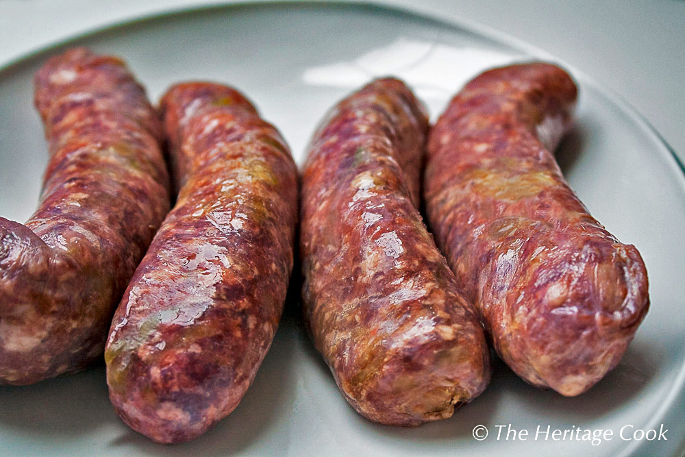 Corned beef sausages on white platter . 