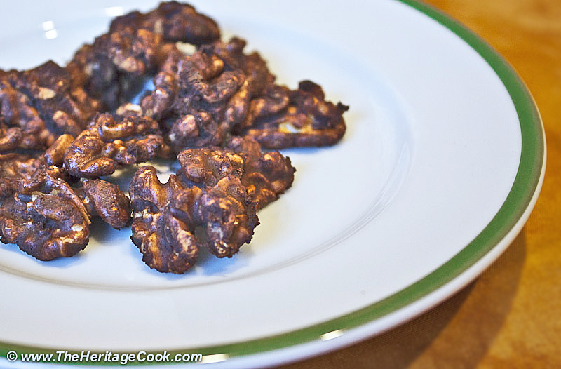 Pile of cocoa-coated walnuts on white plate