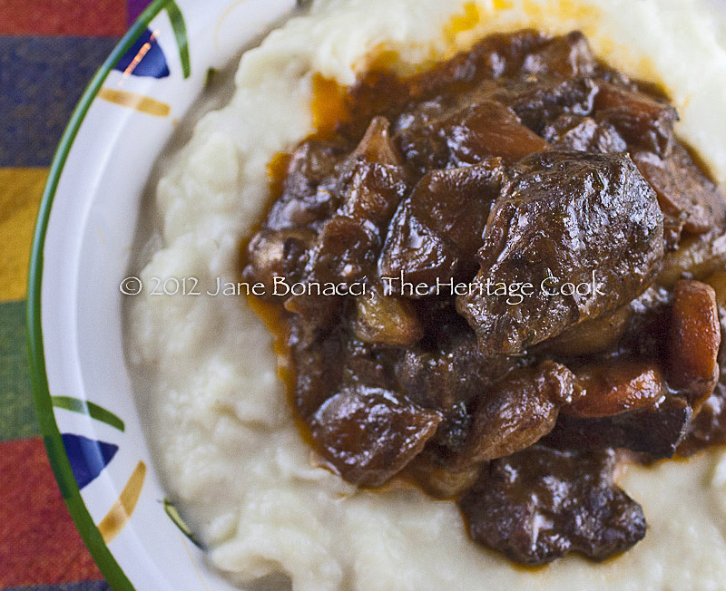 Close up of a bowl of beef bourguignon served over mashed potatoes