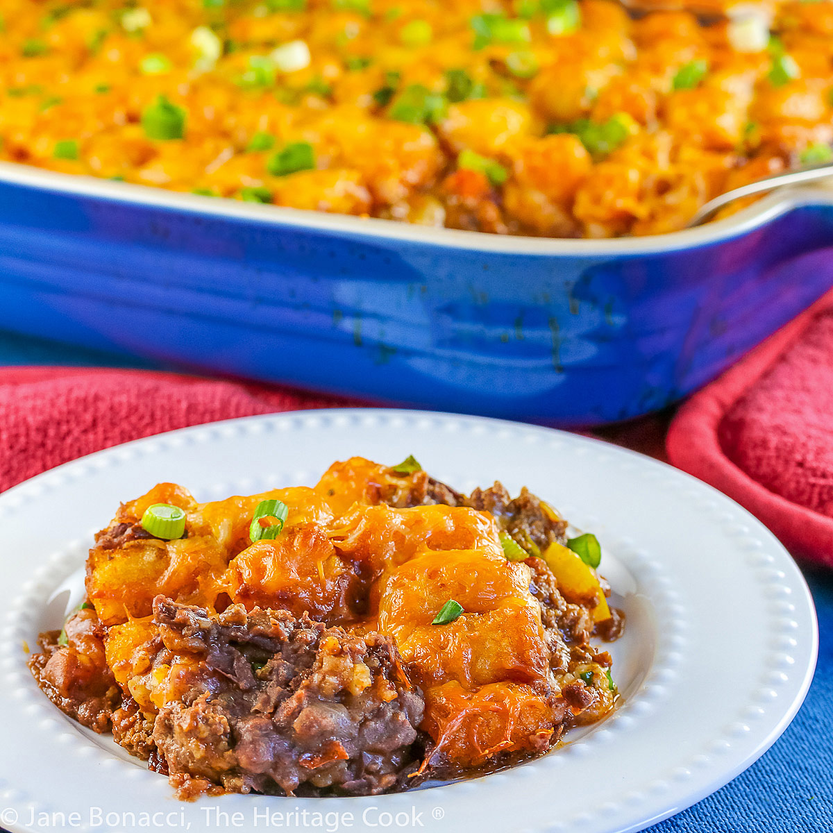 Casserole of Mexican flavored meat spread over refried beans, topped with Tater Tots and cheese then baked; Taco Tot Casserole (Gluten Free) © 2023 Jane Bonacci, The Heritage Cook. 