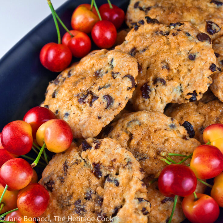 Pile of beautifully baked Chocolate Chip Cherry Scones on a dark blue oval platter; Chocolate Chip Cherry Cream Scones © 2022 Jane Bonacci, The Heritage Cook.