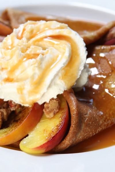Peach Crepes with whipped cream and caramel sauce
