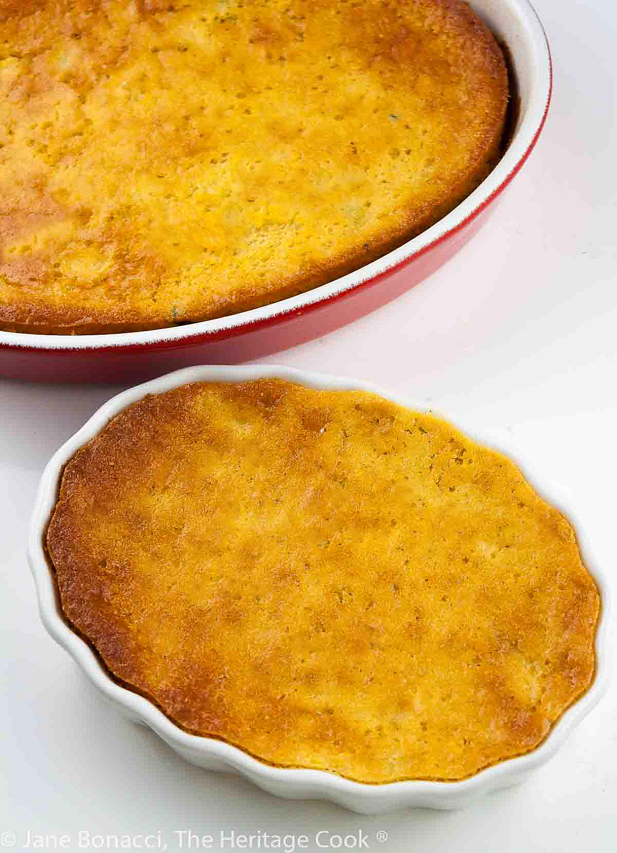 Top down on two baked corn puddings in au gratin dishes. 