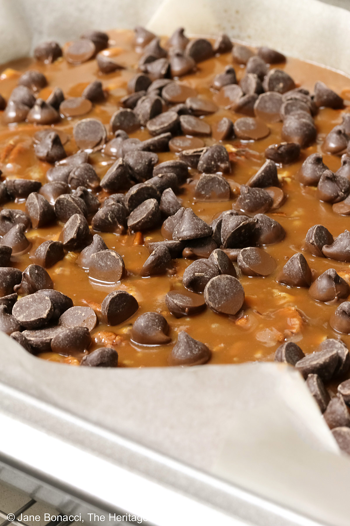 Molten caramel topped with chocolate chips that are melting.