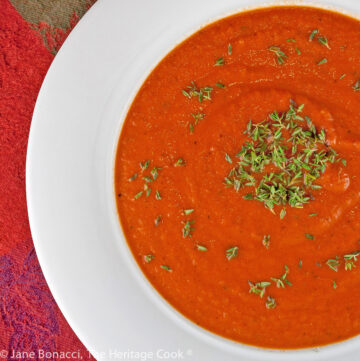 White bowls of red tomato soup with green garnish on top; Italian Cream of Tomato Soup © 2023 Jane Bonacci, The Heritage Cook.