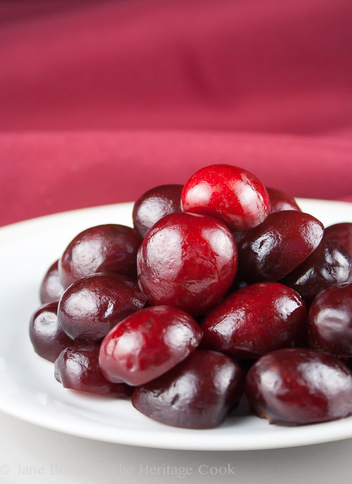 Pile of pitted fresh cherries on white plate