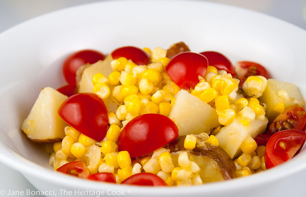 Bowl of fresh corn kernels, potatoes, and cherry tomatoes