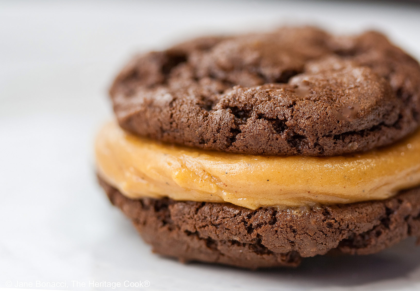 Close up of a single cookie focusing on the filling squeezing out the sides.
