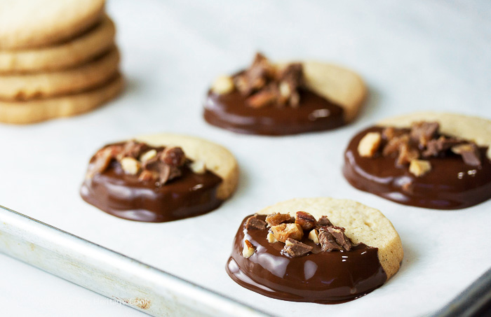 Just dipped cookies topped with chopped toffee: Chocolate Dipped Toffee Topped Sugar Cookies (Gluten-Free); 2015 Jane Bonacci, The Heritage Cook
