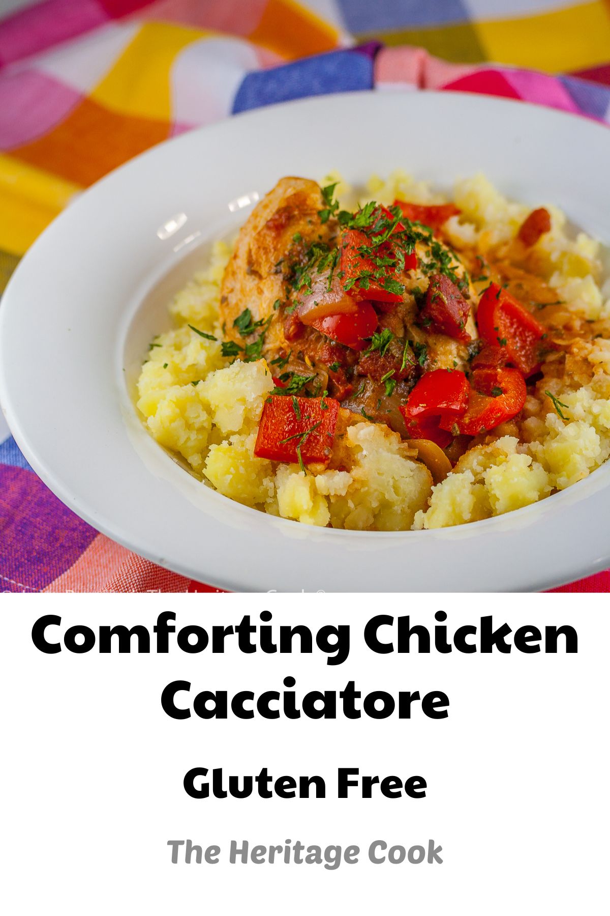 A white bowl with smashed yellow Yukon Gold potatoes is topped with chicken braised in tomatoes, onions, mushrooms, and wine; Comforting Chicken Cacciatore with smashed Yukon Gold potatoes © 2023 Jane Bonacci, The Heritage Cook.