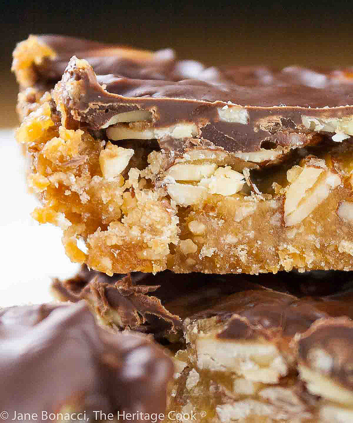 Close up of the Nutty Chocolate Caramel Cookie Bar stacked on top of each other. 