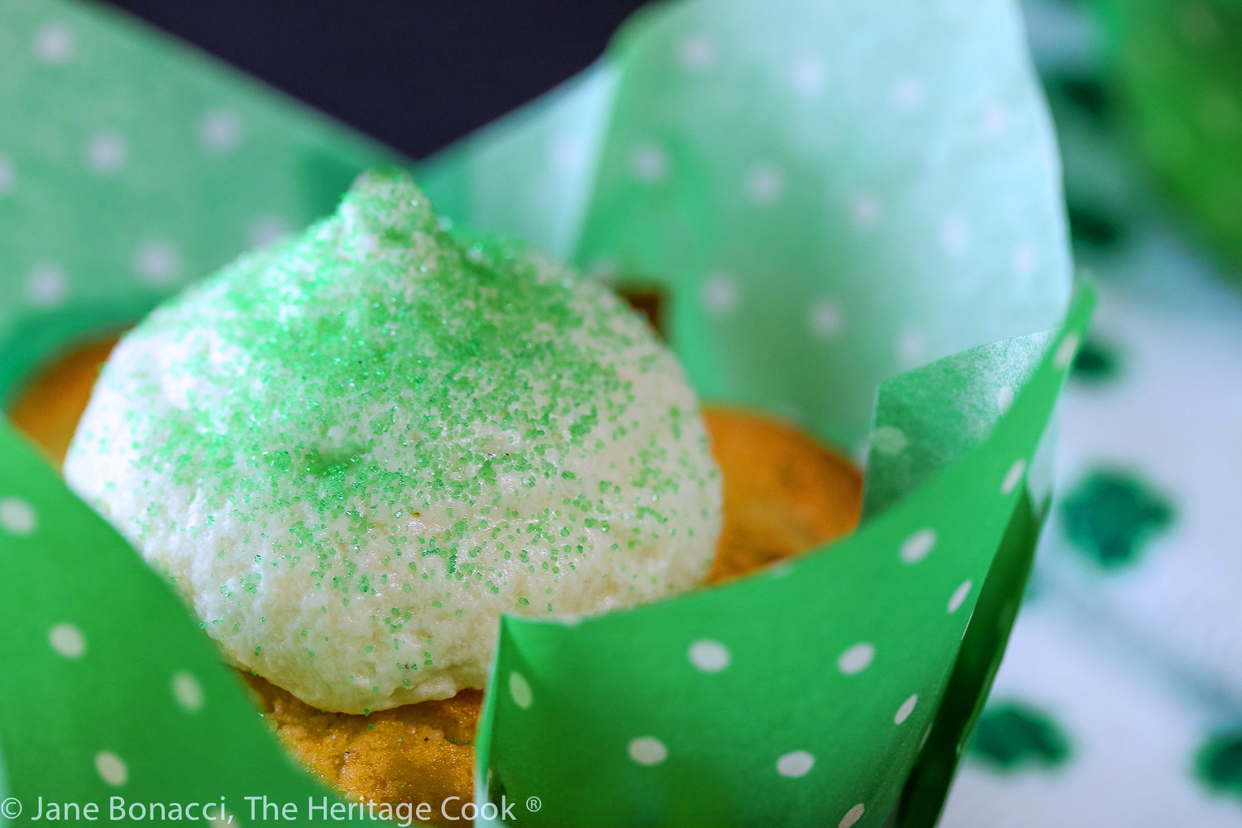 Vanilla cupcakes in festive cupcake papers, some with green frosting and some with white and green sugar sprinkles; Festive luscious chocolate chip buttermilk cupcakes with a surprise inside, perfect for any holiday © 2023 Jane Bonacci, The Heritage Cook. 