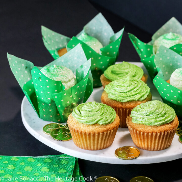 Vanilla cupcakes in festive cupcake papers, some with green frosting and some with white and green sugar sprinkles; Festive luscious chocolate chip buttermilk cupcakes with a surprise inside, perfect for any holiday © 2023 Jane Bonacci, The Heritage Cook.