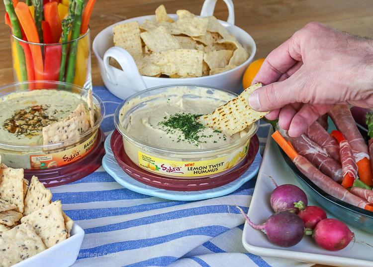 Hand dipping chip in hummus; Sabra's Unofficial Meal for Casual Gatherings; © 2016 Jane Bonacci, The Heritage Cook