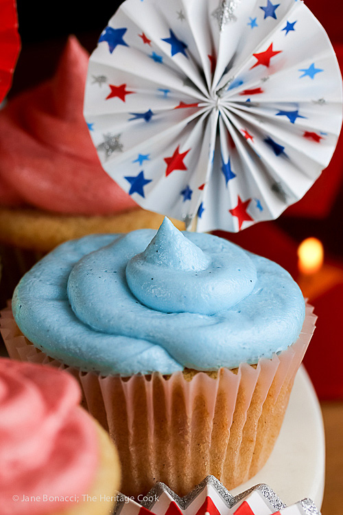 Vanilla cupcakes with blue tinted buttercream frosting and 4th of July decorations