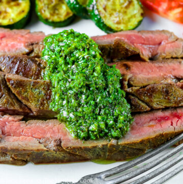 Slices of Flank Steak grilled and served with green herb Chimichurri sauce, sautéed zucchini, and sliced tomatoes © 2023 Jane Bonacci, The Heritage Cook.
