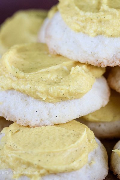 Close up of a cookie pile; Lemon White Chocolate Sugar Cookies with Lemon Buttercream Frosting © 2018 Jane Bonacci, The Heritage Cook