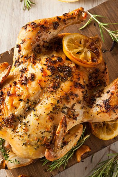 top down look at whole roasted chicken with lemon pieces & fresh herbs; Lemon and Cumin Scented Chicken from The Heritage Cook 2018 Jane Bonacci, The Heritage Cook