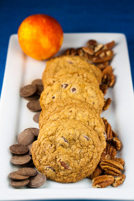 Platter of cookies surrounded by chocolate chips and pecans; Orange Scented Gluten Free Chocolate Chip Cookies © 2018 Jane Bonacci, The Heritage Cook