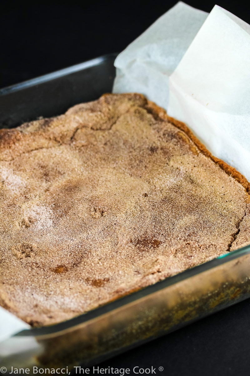Baked Snickerdoodle Bars in the pan with a parchment sling