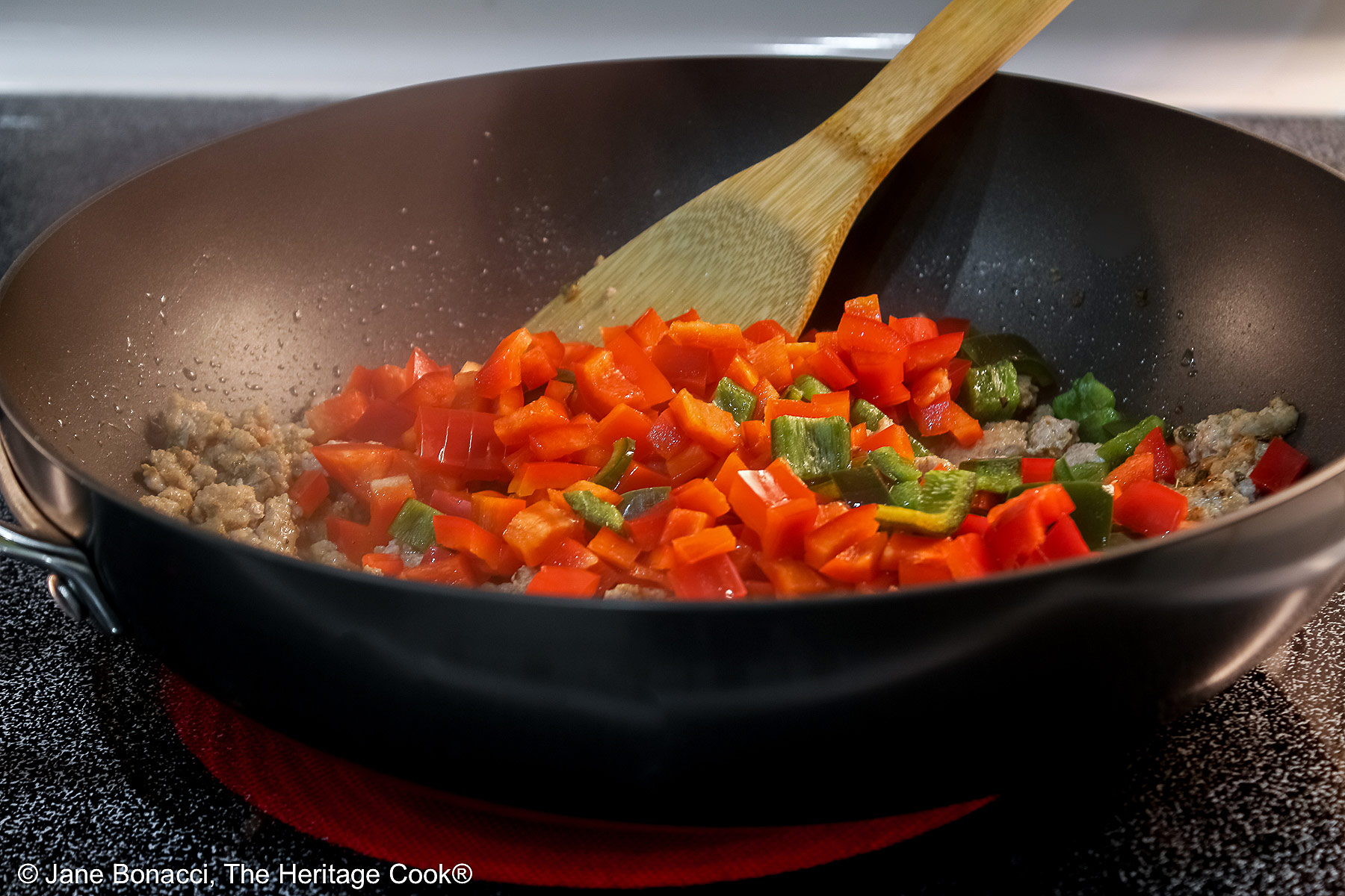 Sautéing the vegetables and meat before assembly in deep large skillet. 