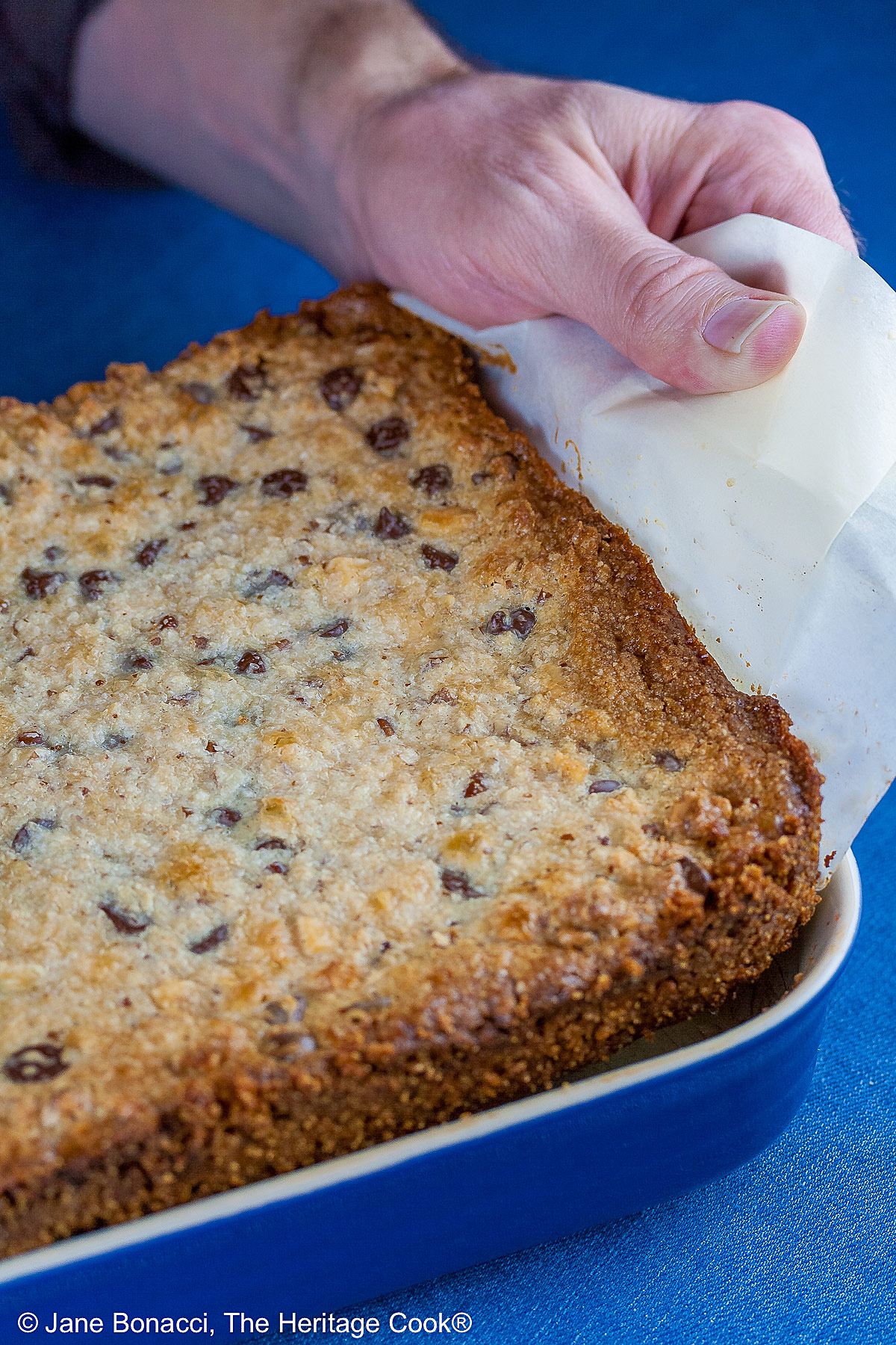Using the parchment paper to lift the bars out of the pan. 