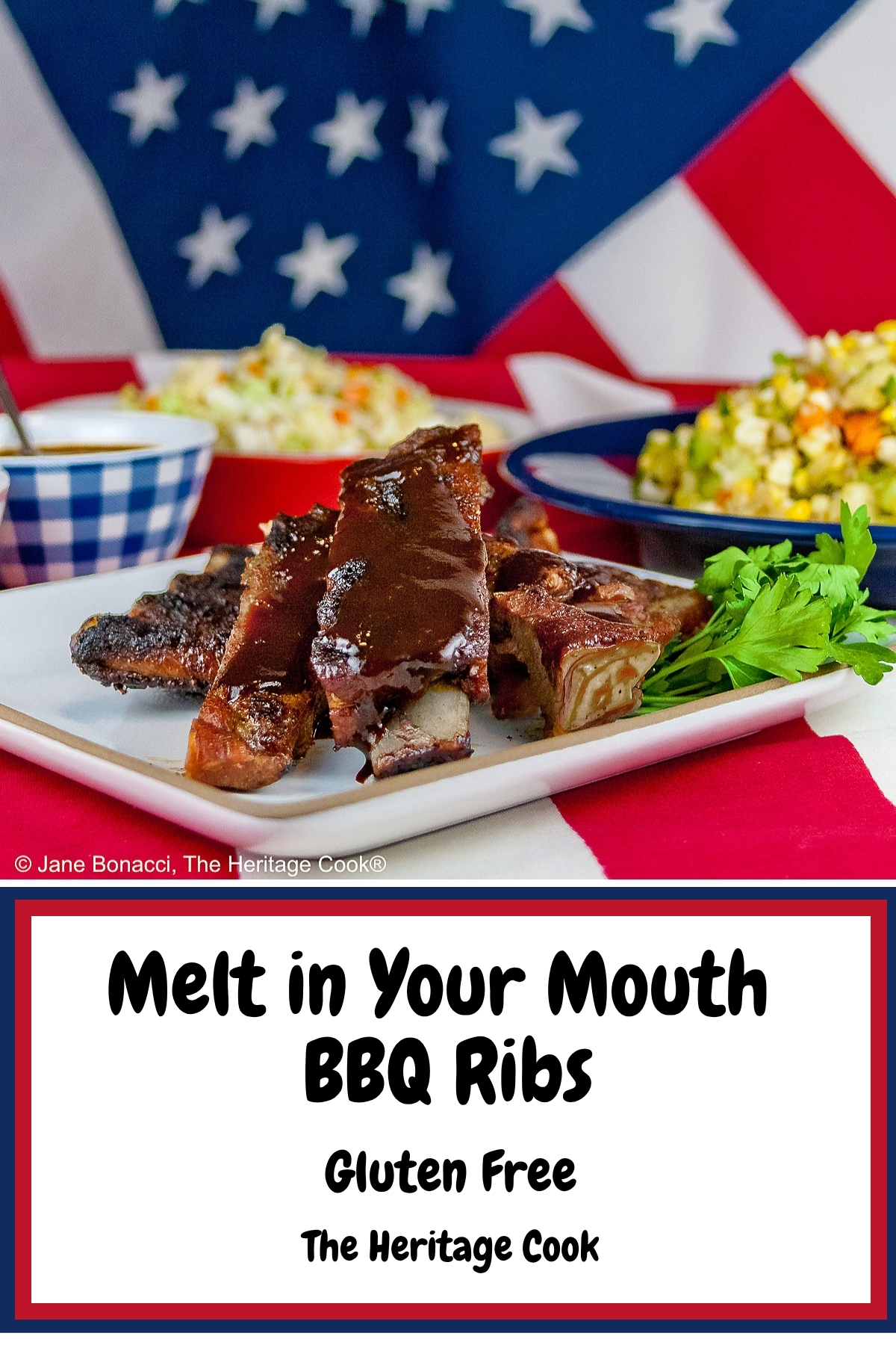 Melt in Your Mouth Ribs with a dry rub on them, wrapped tightly in foil, then cooked to beautiful tenderness, then served brushed with BBQ sauce on a white plate and served with coleslaw, baked beans, and corn salad sitting on an American flag in celebration of the 4th of July © 2026, Jane Bonacci, The Heritage Cook.