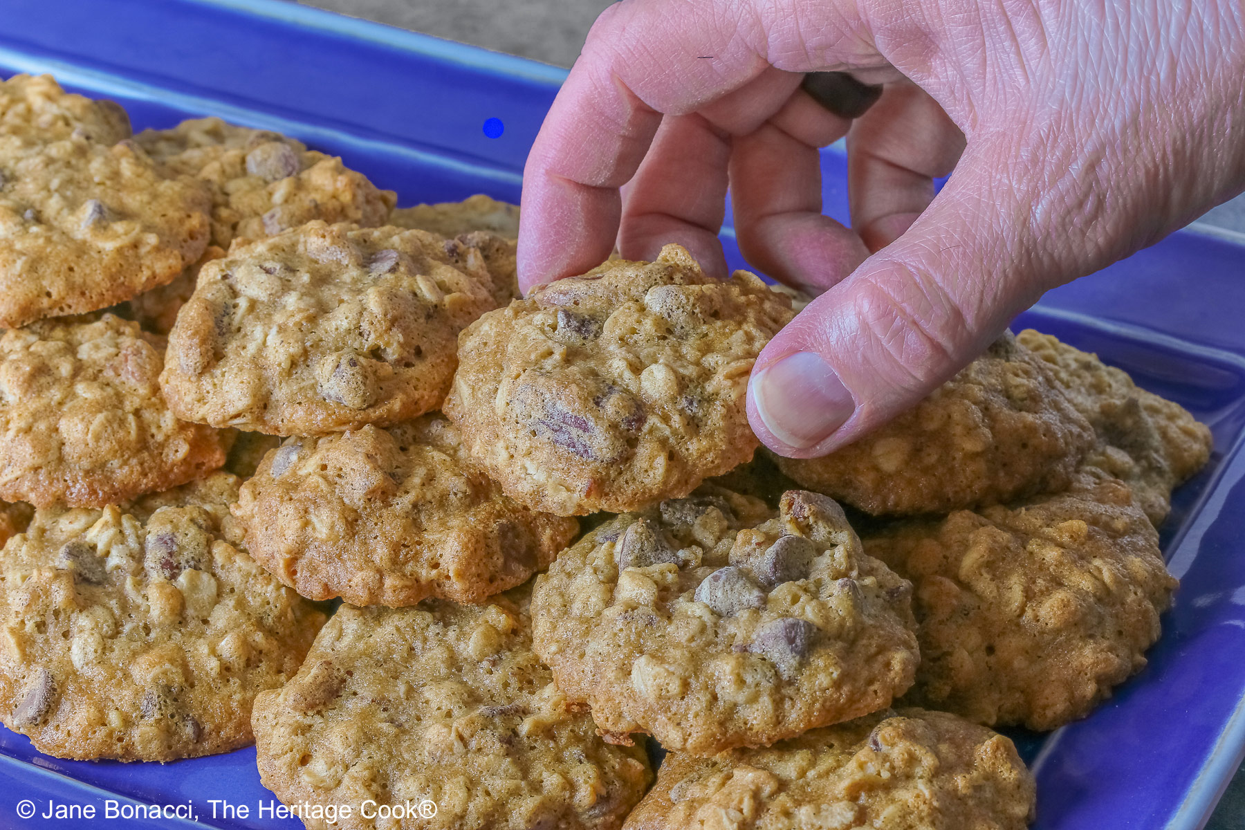 Male hand reaching to grab a cookie.
