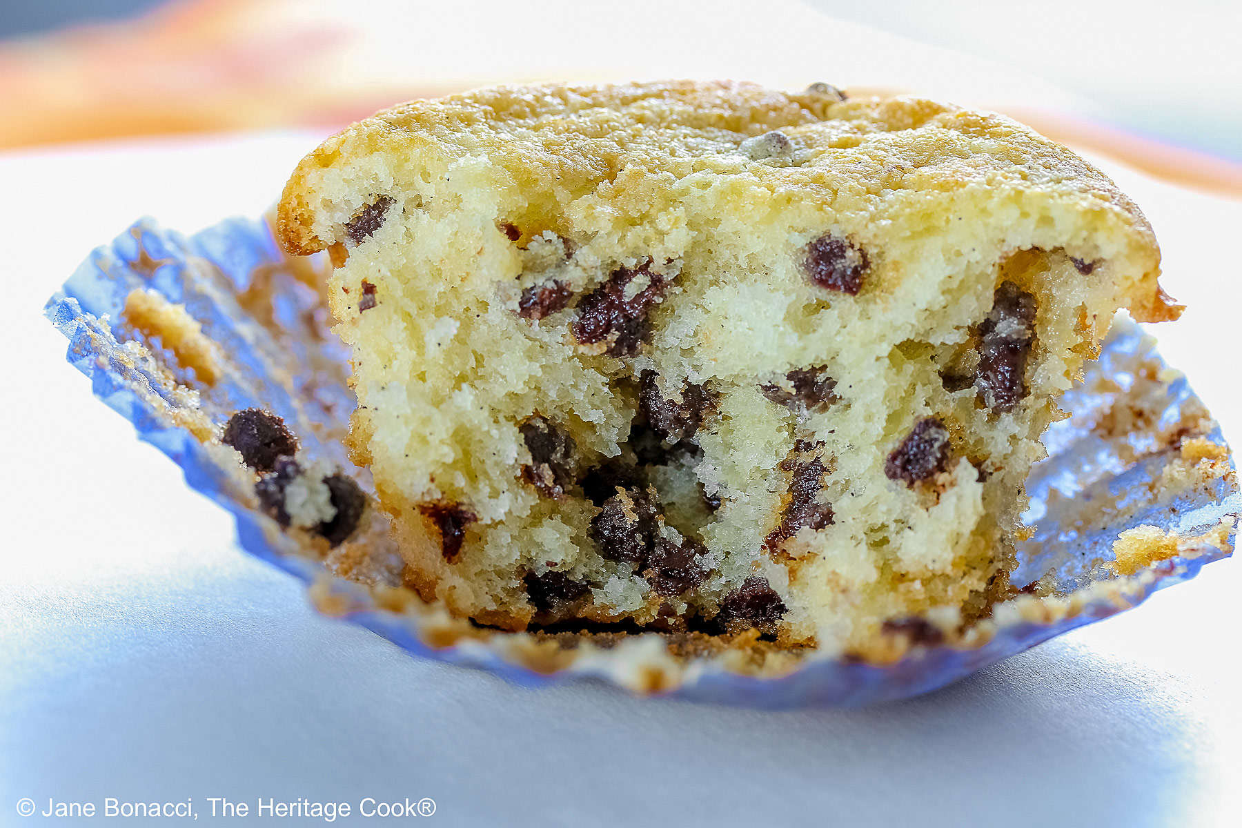 Cupcake cut in half exposing the center and showing the mini chocolate chips. 