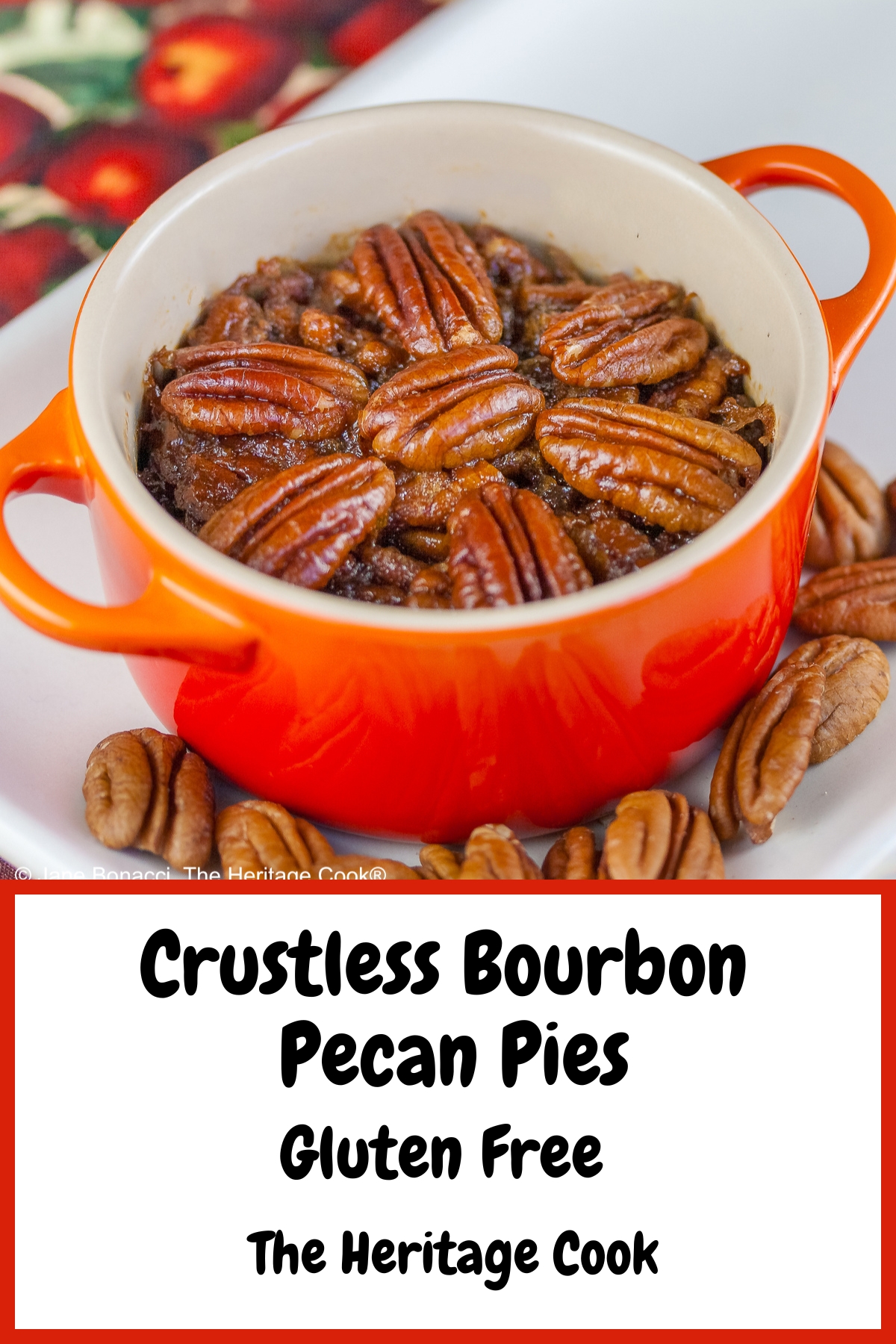 Line of ramekins and cocottes in a variety of colors on a white tray filled with crustless bourbon pecan pies with pecans scattered around, sitting on a cloth covered with red apples and green leaves © 2025 Jane Bonacci, The Heritage Cook.