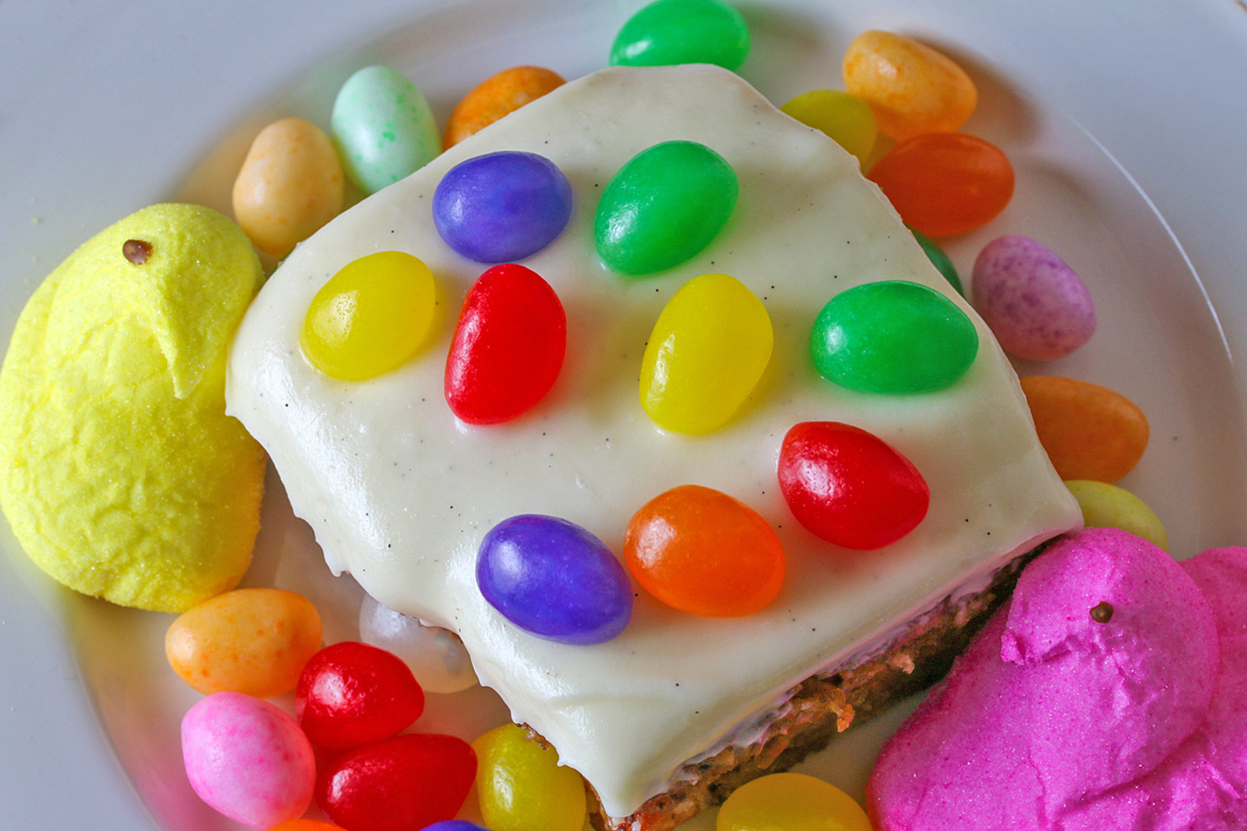 Looking straight down on top of a slice of the cake with colorful jelly beans on top. 