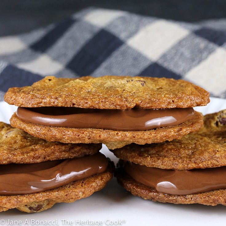 Two chocolate chip cookies with Nutella between them make Nutella Sandwich Cookies, a chocoholic's dream dessert! © 2021 Jane Bonacci, The Heritage Cook