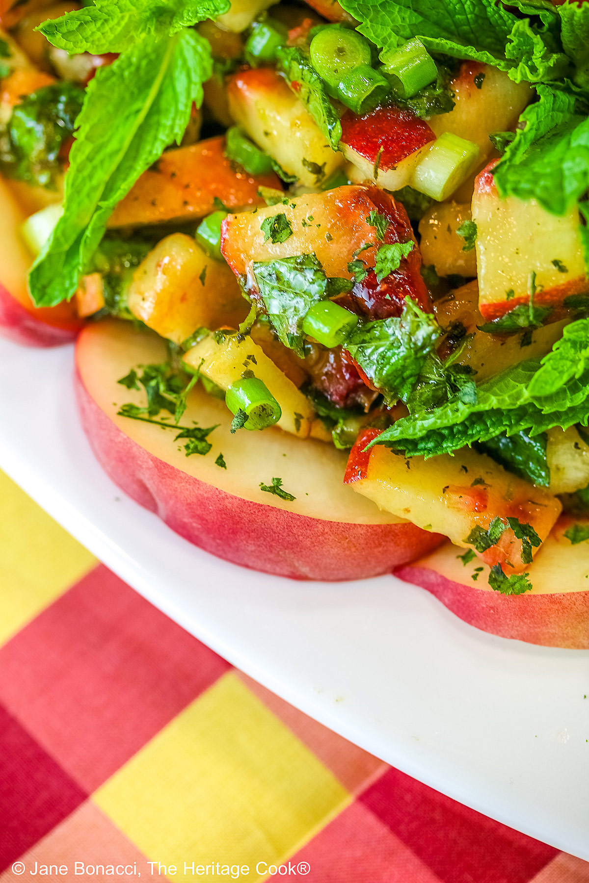 Close up of peach Chimichurri and peach slices on a white platter. 