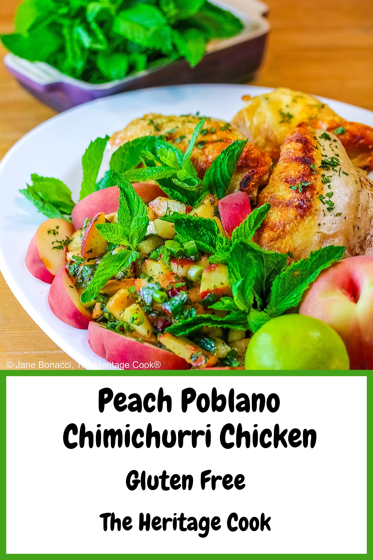 Grilled chicken breast halves piled on a white platter with the chunky peach poblano chimichurri in front with peach wedges around the edge and multiple mint sprigs tucked into the top © 2025 Jane Bonacci, The Heritage Cook. 