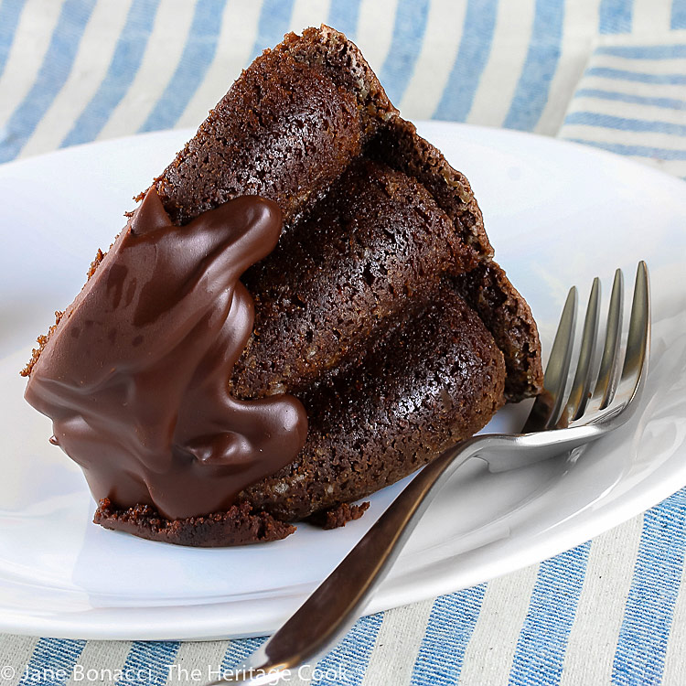 slice of gluten free chocolate bundt cake on white plate with a fork