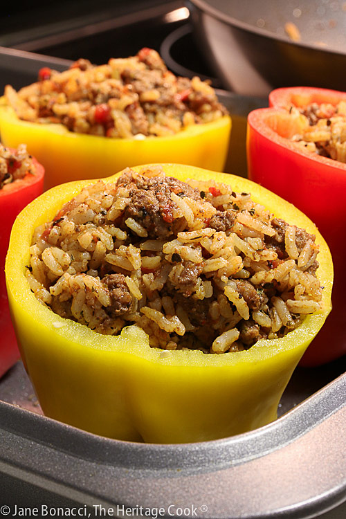 red and yellow peppers stuffed with filling, ready for baking