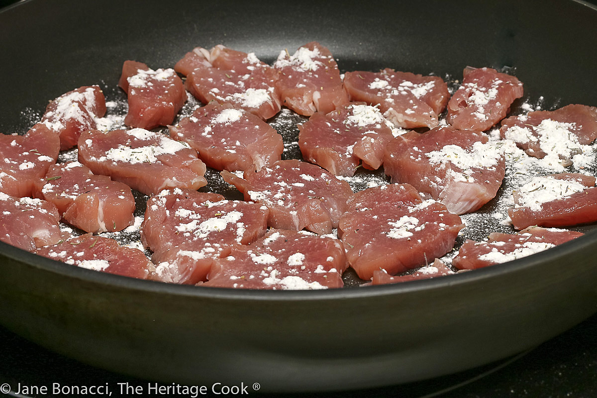 Pan of sliced pork sprinkled with flour