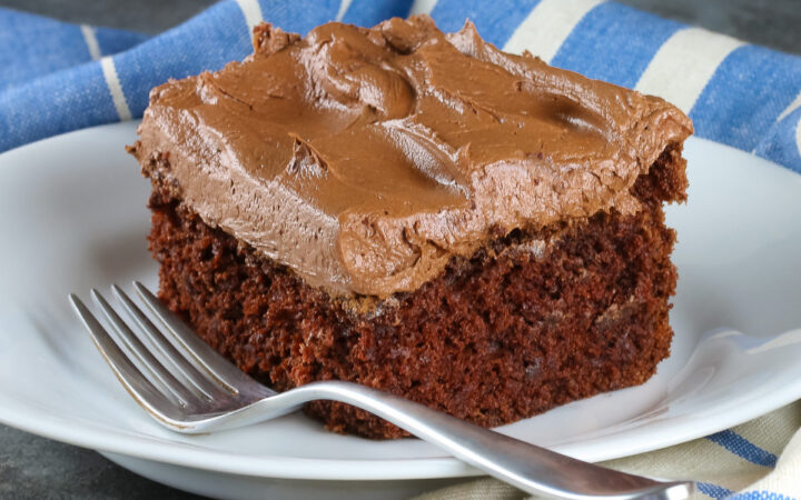 Slice of cake on white plate with blue & white linen cloth; Brooklyn Blackout Chocolate Cake © 2022 Jane Bonacci, The Heritage Cook.