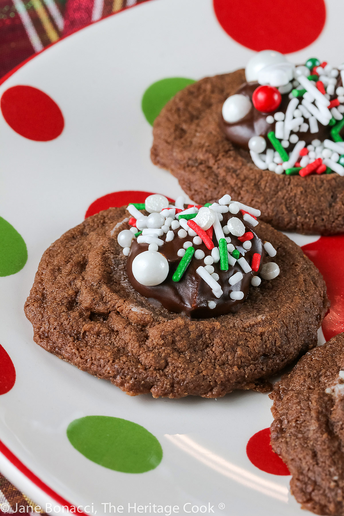 Small cookie cups filled with mint chocolate ganache and topped with festive holiday sprinkles; Hot Chocolate Mint Thumbprint Cookies © 2022 Jane Bonacci, The Heritage Cook. 