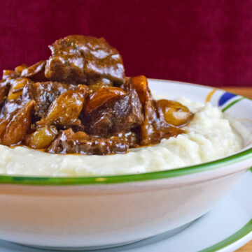 Bowl of beef burgundy stew on mashed potatoes in bowl; Julia’s Simplified Beef Bourguignon © 2022 Jane Bonacci, The Heritage Cook.