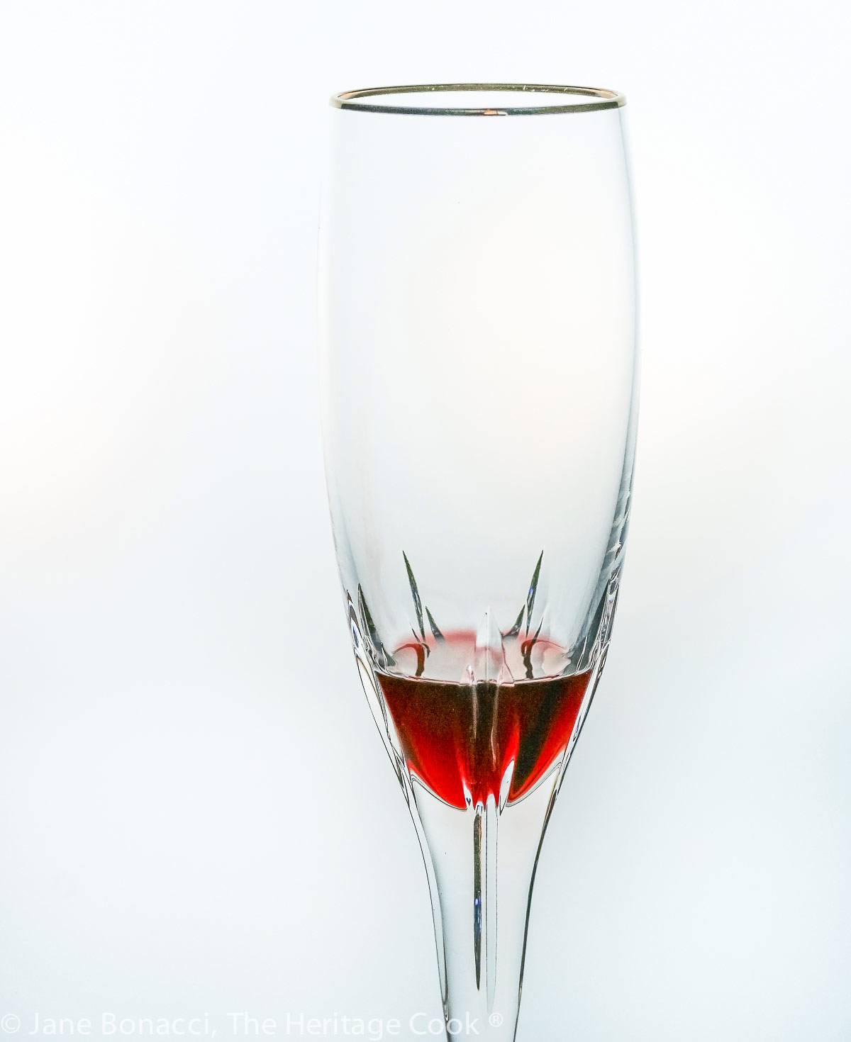 crystal flute glass with some red cassis in the bottom. 