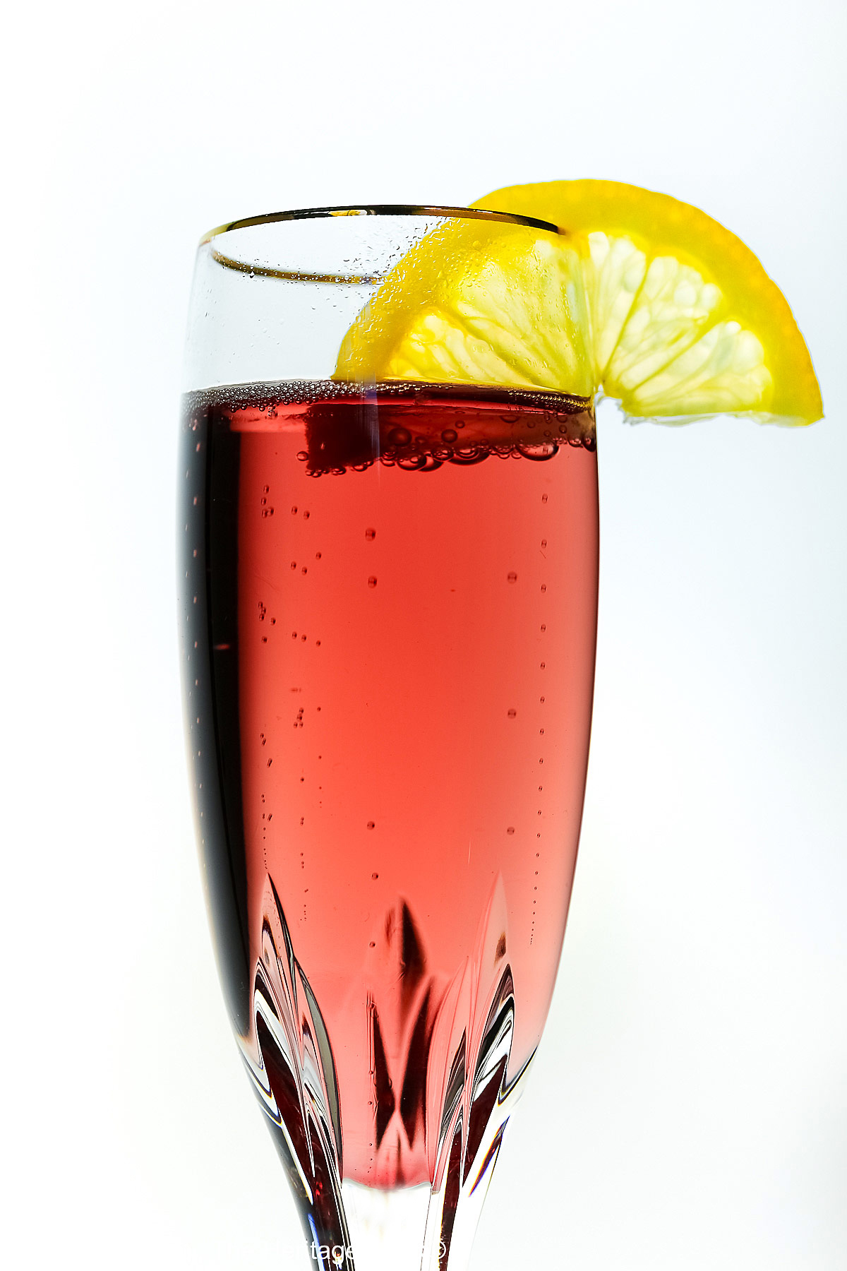 Kir Royale Champagne Cocktails are made with ruby red crème de cassis (black currant liqueur) combined with champagne to make these beautiful pink cocktails, served in crystal flutes on a white background © 2025 Jane Bonacci, The Heritage Cook.