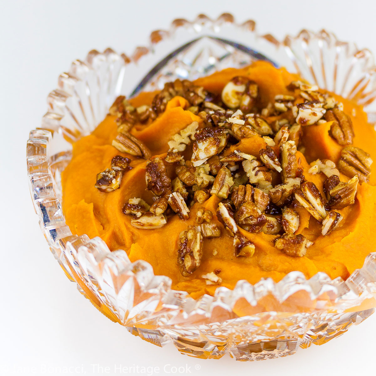 Maple whipped sweet potatoes topped with candied chopped pecans in two bowls, one cut glass; Maple Whipped Sweet Potatoes © 2022 Jane Bonacci, The Heritage Cook.