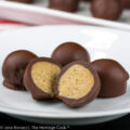 Chocolate covered round coconut and almond truffles on white plate or small platter, some cut in half to show centers; Almond Coconut Truffles © 2022 Jane Bonacci, The Heritage Cook.