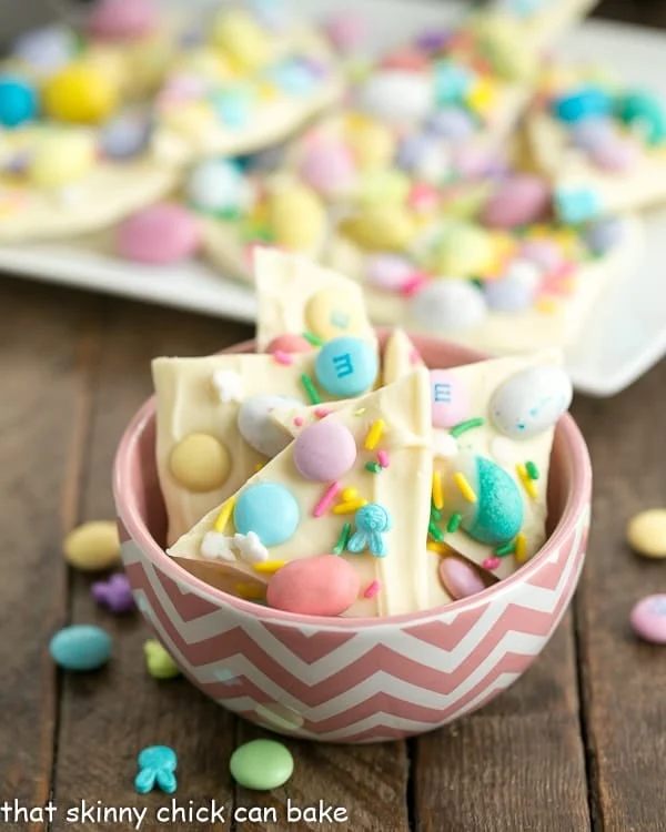 Colorful Easter egg bark in pink basket; 21 different chocolate treats in this blog post round-up are swoon-worthy; 21 Chocolate Easter Treats round-up 2023; assembled by Jane Bonacci, The Heritage Cook. 