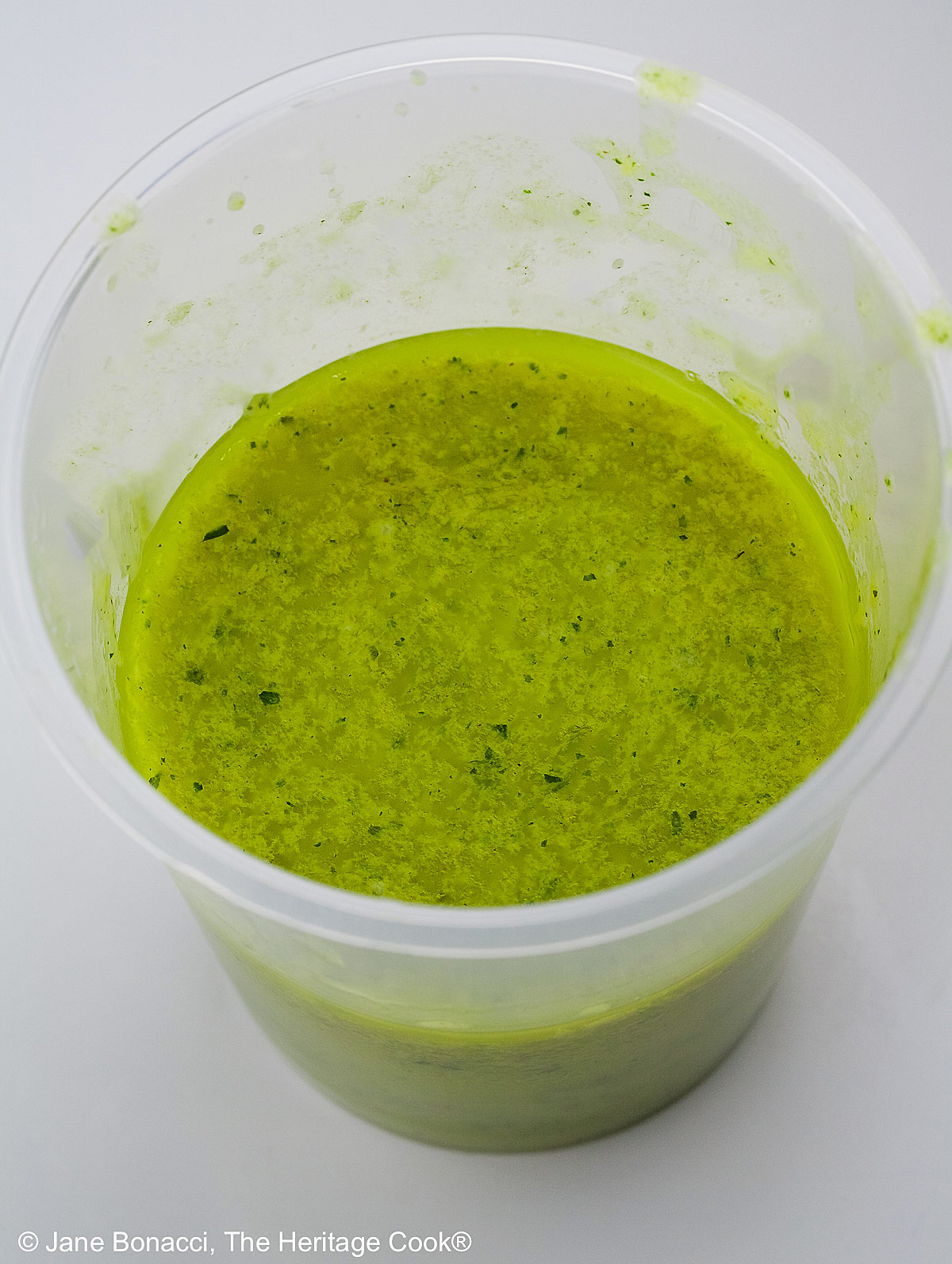 A cup of the green hollandaise sauce made with an immersion blender.