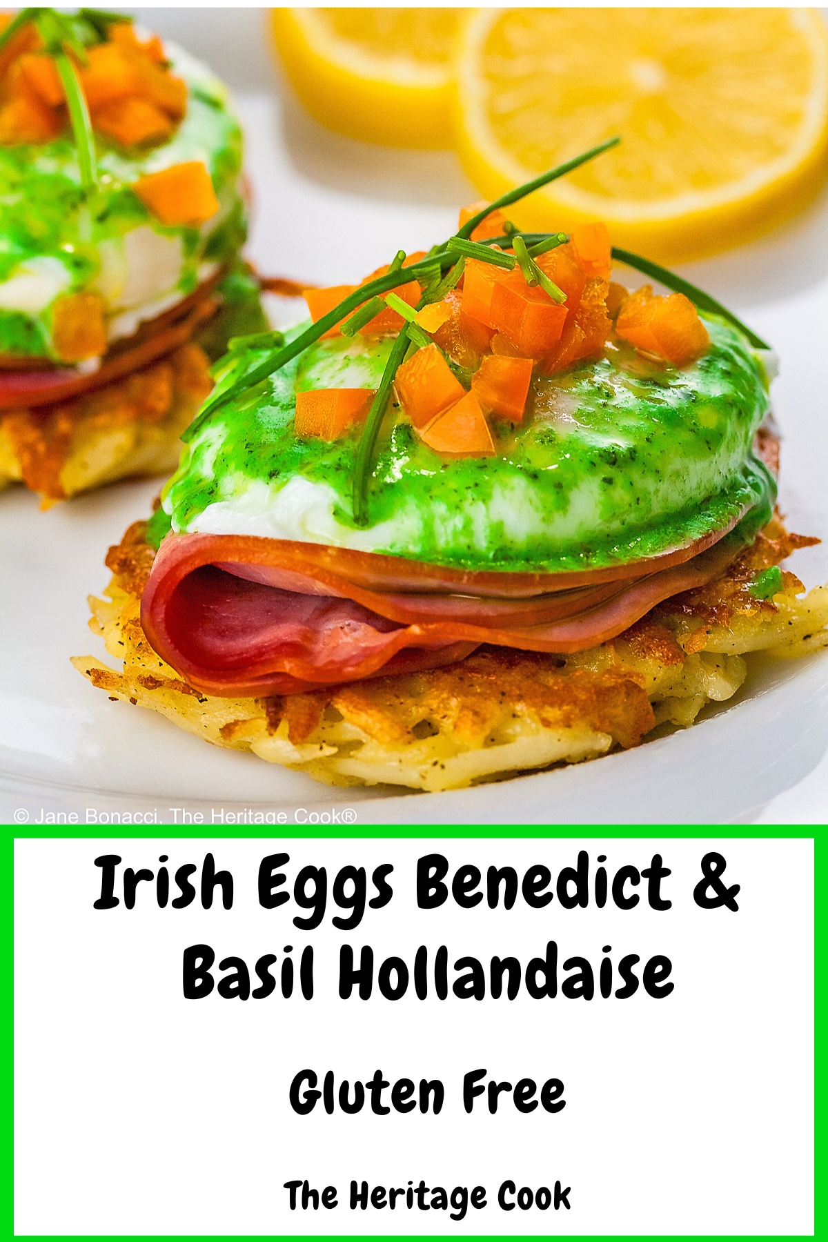 Two beautifully poached eggs laid on top of a slice of ham on a fried hash brown patty and topped with bright green hollandaise sauce, orange bell pepper cubes, and chives to mimic the colors of the Irish flag, on a white plate with two slices of lemon © 2026 Jane Bonacci, The Heritage Cook.