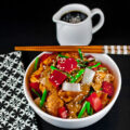 Rice bowls topped with teriyaki coated chicken pieces with red bell peppers, onions, asparagus, and sesame seeds; Orange Teriyaki Chicken Bowls © 2023 Jane Bonacci, The Heritage Cook.