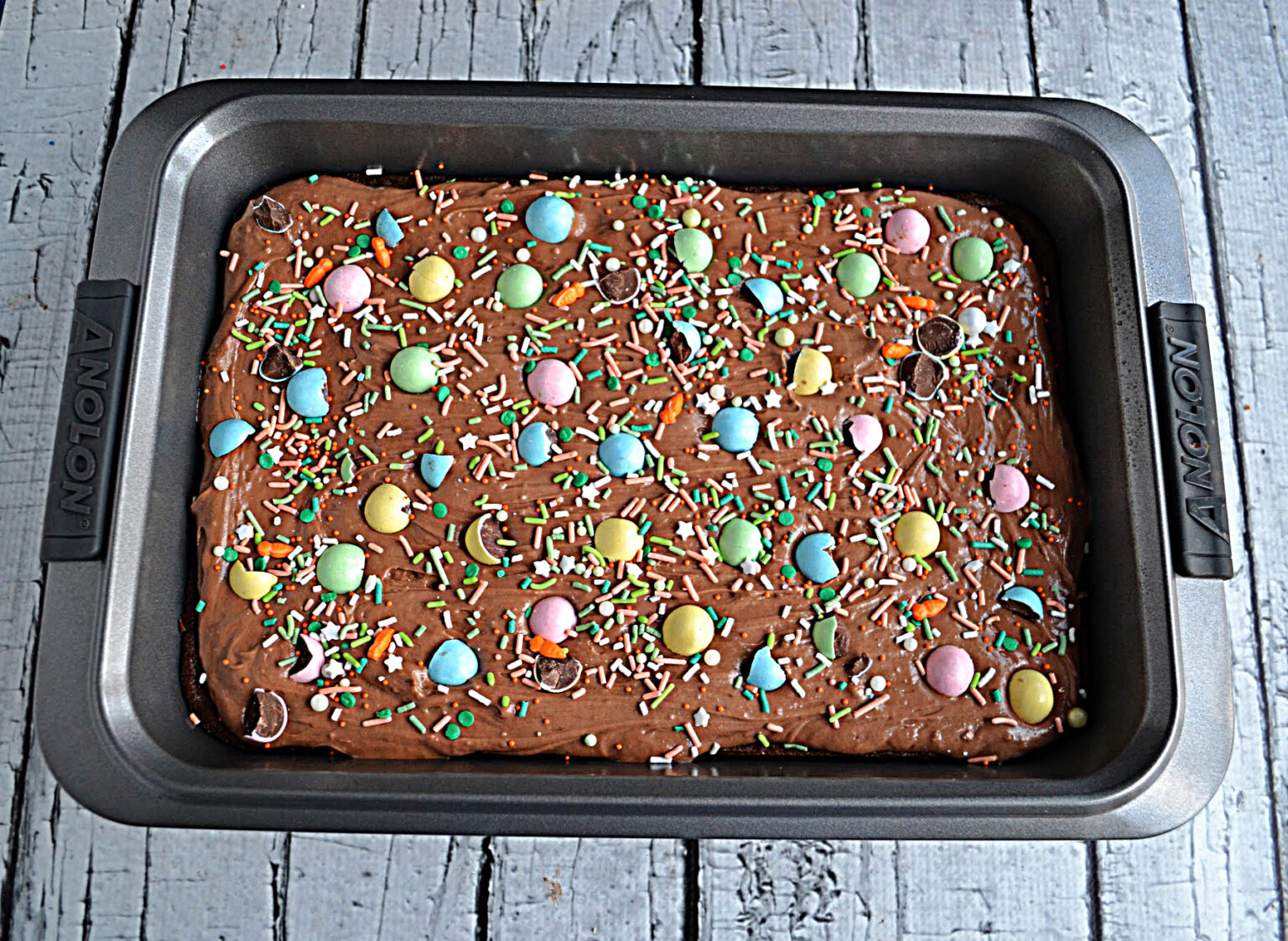 Malted chocolate frosted brownies with small candy eggs scattered over the surface; 21 different chocolate treats in this blog post round-up are swoon-worthy; 21 Chocolate Easter Treats round-up 2023; assembled by Jane Bonacci, The Heritage Cook. 
